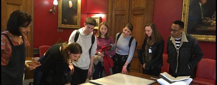a group of young people looking at maps laid out on a table